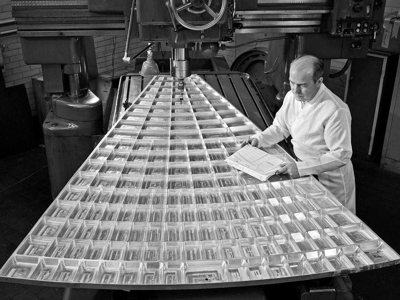 NASA Technician checks parts to see if meet specs on blueprint 1960s