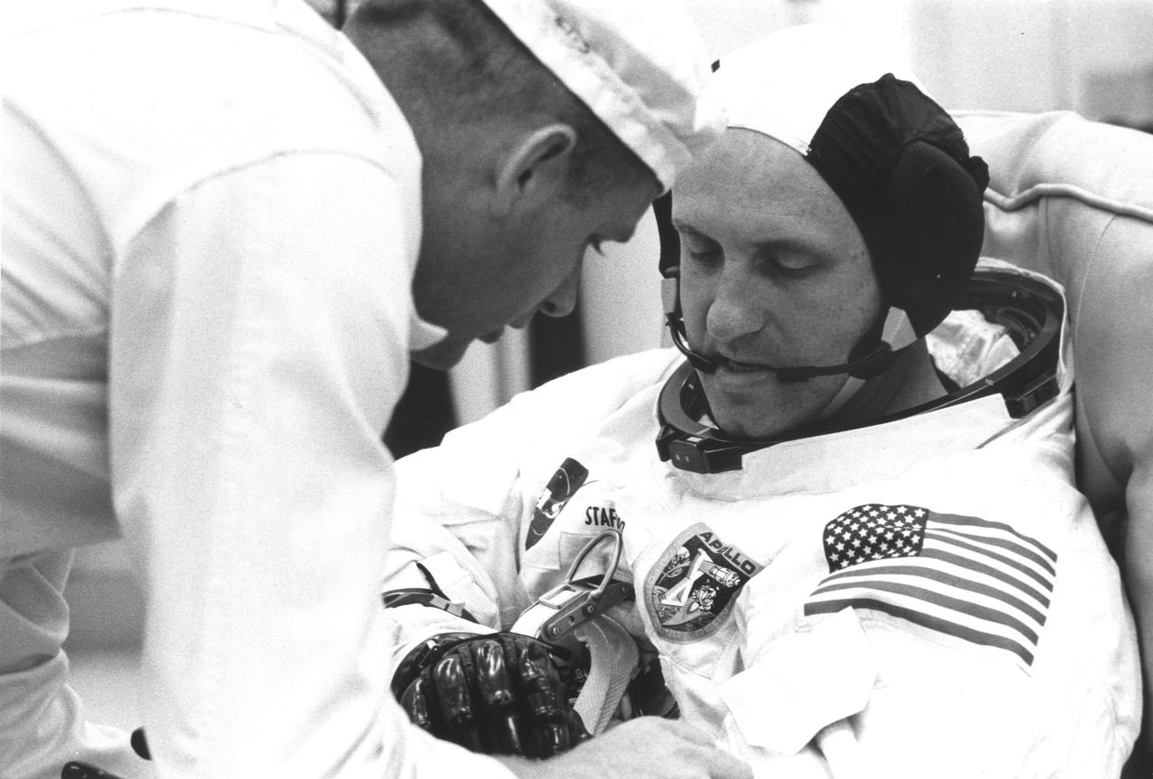NASA astronaut having spacesuit checked by tech 1960s
