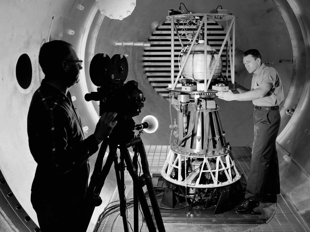 NASA Cameraman films a technicial with rocket part 1960s